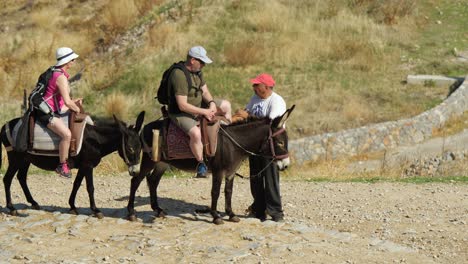 Tourist-couple-riding-dongkeys-at-Lindos-Acropolis