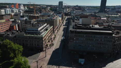Aerial-view-around-a-bus,-driving-on-the-streets-of-Tampere,-sunny-summer-day-in-Finland---circling,-drone-shot