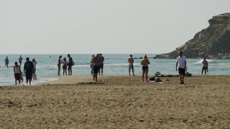Gente-En-La-Playa-De-Prasonisi,-Algunos-De-Ellos-Caminando-Por-El-Mar-Poco-Profundo.
