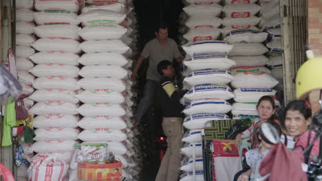 Männer-Organisieren-Und-Tragen-Schwere-Säcke-Reis-Auf-Einem-Reismarkt-Im-Freien-In-Phnom-Penh