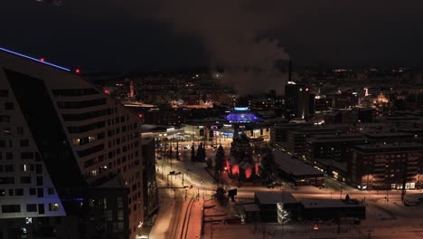 Vista-Aérea-Hacia-El-Iluminado-Distrito-De-Ratina-De-Tampere,-Noche-De-Invierno-En-Finlandia