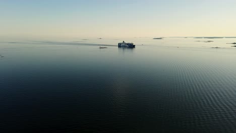 Aerial-view-towards-a-Baltic-shuttle-ship-on-the-open-sea,-sunset-in-Finland---approaching,-drone-shot