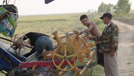 Kambodschanische-Bauern-Reparieren-Einen-Reiserntetraktor