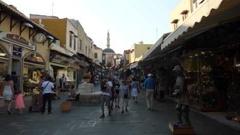 Busy-shopping-street-in-Rodos-Town,-Mosque-of-Suleiman-at-the-end