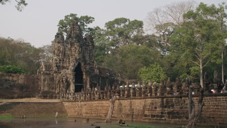 Quick-pan-from-Peaceful-lake-to-Angkor-Wat-temple-entrance-gate
