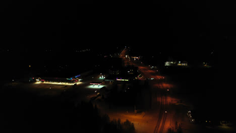 Aerial-drone-view-overlooking-town-of-Akaslompolo,-winter-night,-in-Finland