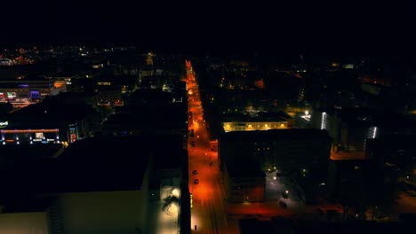 Aerial-view-overlooking-lit-up-streets-of-Kuopio,-winter-night-in-Finland---circling,-drone-shot