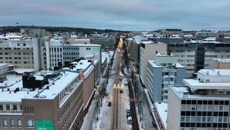 Aerial-drone-view-over-the-main-street-in-downtown-Lahti,-winter-evening,-in-Finland