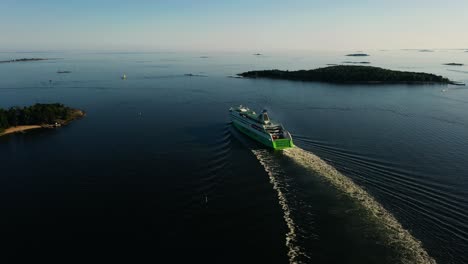 Aerial-view-around-a-cruise-liner-passing-islands-on-the-Gulf-of-Finland,-summer-evening-in-Finland---circling,-drone-shot