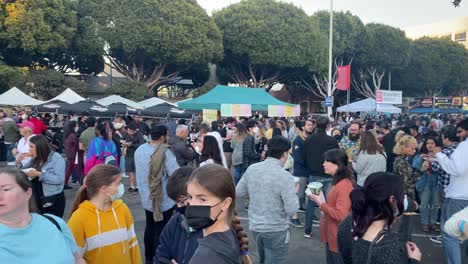 A-large-crowd-of-people-enjoying-Asian-food-at-the-626-Santa-Monica-night-market-mini,-in-Los-Angeles---pan-view