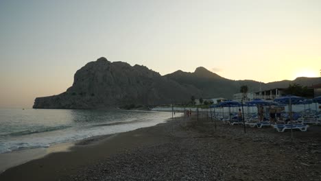 Kolymbia-Beach-at-sunset,-Hills-in-background