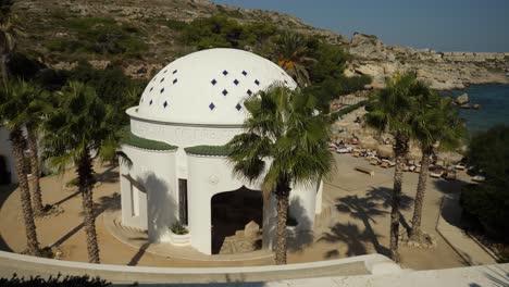 White-dome-building-of-Kallithea-Springs-near-the-beach-with-sunbathing-people
