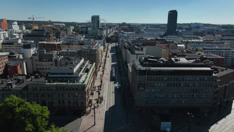 Aerial-view-overlooking-a-tram-on-the-streets-of-Tampere,-sunny,-summer-day-in-Finland