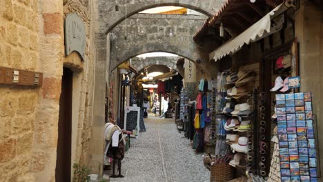 Narrow,-rocky-walking-street-with-souvenir-shops-in-the-Old-Town-of-Rhodes