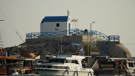 Small-orthodox-church-surrounded-by-boats-at-Kolymbia-Harbour