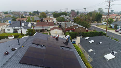Dos-Hombres-Instalando-Paneles-Solares-En-El-Techo-De-Una-Casa-Residencial-Moderna-En-Los-Ángeles,-EE.UU.
