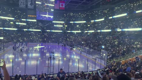 Tampa-Bay-Lightning-Spieler-Betreten-Das-Eis-Zu-Beginn-Eines-Spiels-Auf-Einer-Eishockeyhalle,-Bei-Ausgeschaltetem-Licht-Und-Jubelnder-Menge
