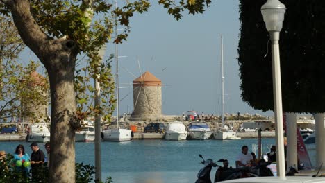 Boats-moored-in-front-of-the-old-stone-windmills-at-the-harbour-of-Rodos-Town