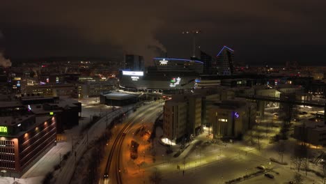 Aerial-drone-view-towards-the-illuminated-Nokia-arena,-winter-evening-in-Tampere,-Finland