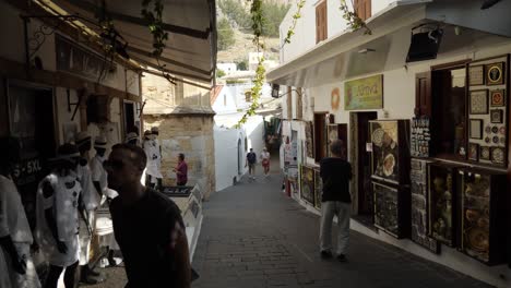 People-in-a-narrow-street-of-Lindos,-Part-one