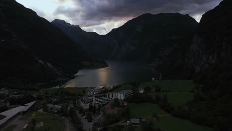 Aerial-view-of-the-Geirangerfjord-and-the-Hotel-Union-Geiranger-AS,-in-gloomy-Norway---Descending,-drone-shot