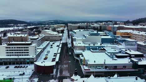 Aerial-view-over-streets,-in-snowy-Jyvaskyla,-gloomy,-winter-evening-in-Finland