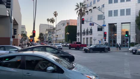 Traffic-at-intersection-in-downtown-Santa-Monica,-sunny-evening-in-Los-Angeles,-USA---static-view