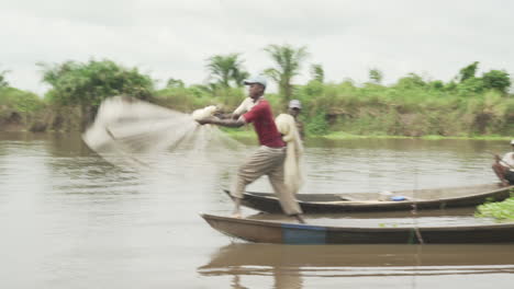 Fischer-Werfen-Ein-Netz-Aus-Einer-Piroge-Auf-Einem-Fluss-In-Benin