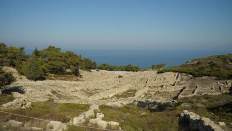 Wide-angle-view-of-the-Acropolis-of-Kamiros,-Tourists-among-the-ruins,-Mediterranean-Sea-in-background
