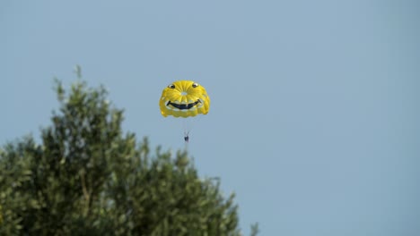Zwei-Personen-Auf-Einem-Gelben-Fallschirm-Mit-Smiley-Gesicht-Beim-Parasailing-An-Der-Küste-Von-Rhodos