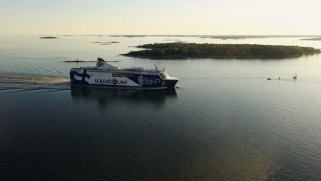Aerial-view-of-a-cruise-liner-passing-islands-on-the-Baltic-sea,-summer-evening-in-Finland---circling,-drone-shot
