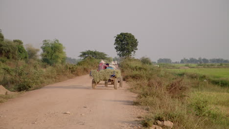 Granjero-Y-Familia-En-Un-Pequeño-Tractor-En-Una-Carretera-Local-En-Camboya-Al-Atardecer