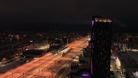 Luftaufnahme-Des-Beleuchteten-Hotels-Torni-Und-Des-Bahnhofs-In-Tampere,-Finnland