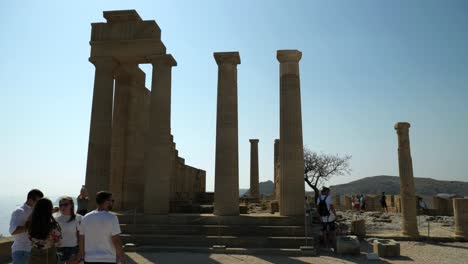 Touristen-An-Den-Säulen-Auf-Der-Spitze-Des-Hügels-Der-Akropolis-Von-Lindos,-Teil-Eins