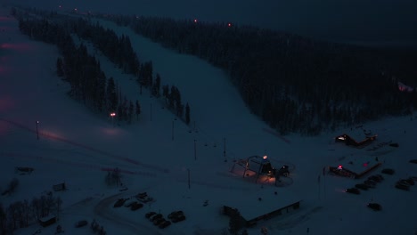 Aerial-view-of-the-slopes-of-Inari-Saariselka,-dark-evening-in-Lapland---circling,-drone-shot