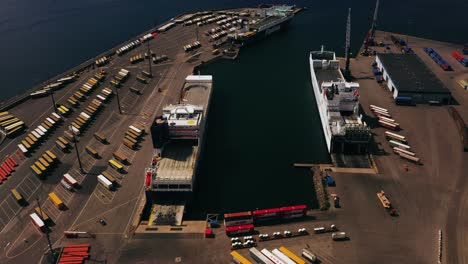 Aerial-view-overlooking-cargo-ferries-at-a-shipping-terminal,-sunny-day-in-Hanko,-Finland---tracking,-drone-shot