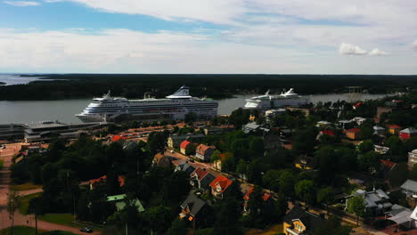 Aerial-view-away-from-passenger-ships-at-the-Mariehamn-port,-in-Ahvenanmaa,-Finland---pull-back,-drone-shot