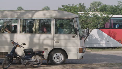 Bus-taking-off-full-of-asian-tourists-at-Angkor-Wat-parking-lot