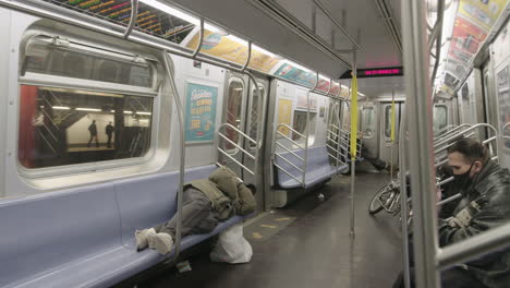 Obdachlose-Männer-Schlafen-In-Der-New-Yorker-U-Bahn-Mit-Menschen,-Die-Gesichtsmasken-Tragen