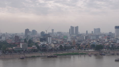Ultra-wide-shot-of-Phnom-Penh-and-Tonle-Sap-river-under-Polluted-sky-pan-left