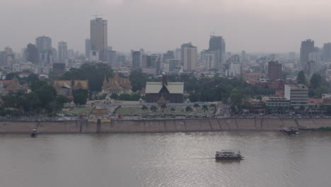 Zoom-out-from-Ferry-Boat-on-Tonle-sap-River-to-Phnom-Penh-Skyline