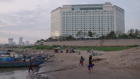 Cambodian-Kids-playing-in-slum-fisherman-village-in-front-of-newly-fancy-hotel-in-Phnom-Penh