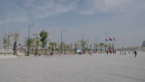 Win-Win-Gedenkplatz-Mit-Händlern-Und-Statuen-Im-Vordergrund-In-Phnom-Penh,-Pfanne-Rechts