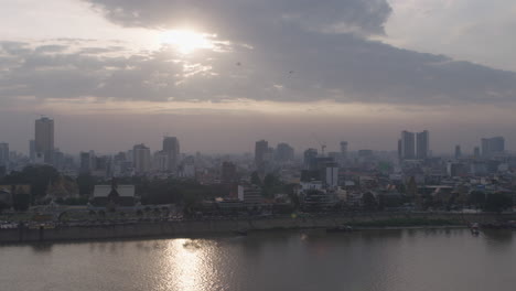 Sonnenuntergang-Auf-Der-Verschmutzten-Skyline-Von-Phnom-Penh,-Schwenk-Nach-Links