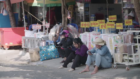 Kambodschanische-Frauen-Und-Männer-Telefonieren-Vor-Einem-Outdoor-Markt-In-Phnom-Penh