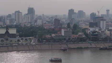 Langsame-Weite-Pfanne-Des-Verschmutzten-Phnom-Penh,-Die-Einer-Fähre-Auf-Dem-Fluss-Tonle-Sap-Folgt