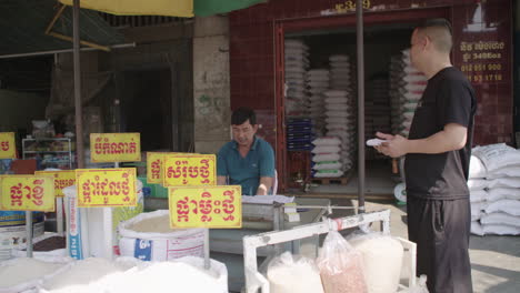 Comerciante-Haciendo-Un-Trato-En-Su-Puesto-De-Arroz-En-La-Calle-En-Phnom-Penh.