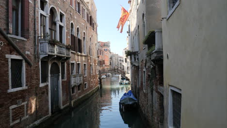 Typical-Quiet-Canal-in-Venice-with-Waving-Venetian-Flag