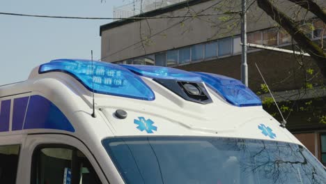 Blue-flashing-siren-on-roof-of-ambulance-car