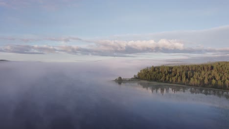 Blauer-Morgenhimmel-über-Nebligem,-Ruhigem-See,-Skandinavische-Waldlandschaft,-Drohnenschub
